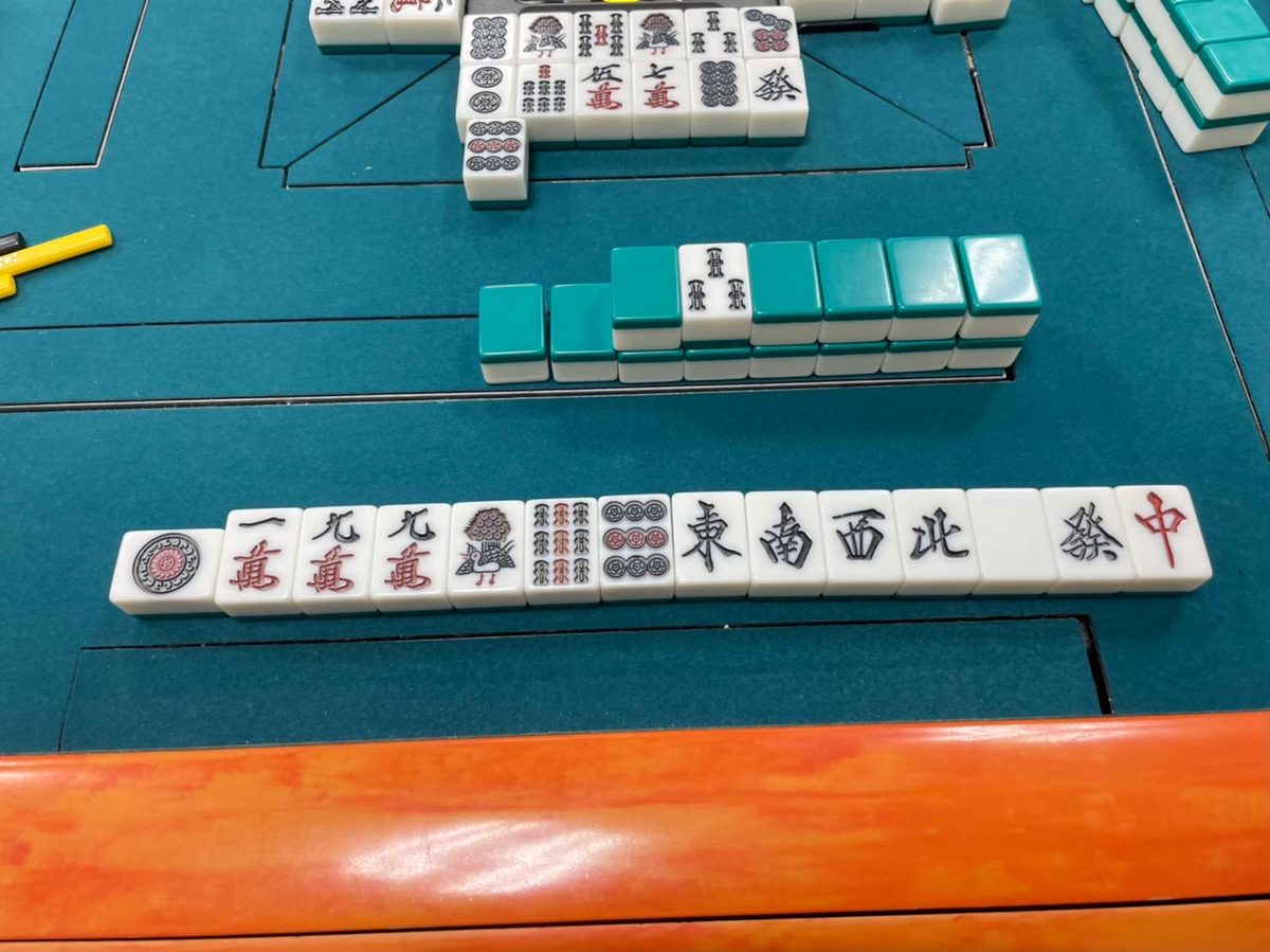 全自動卓の上に並べた麻雀牌。一筒・一萬・九萬・一索・九筒と東南西北・白發中の字牌